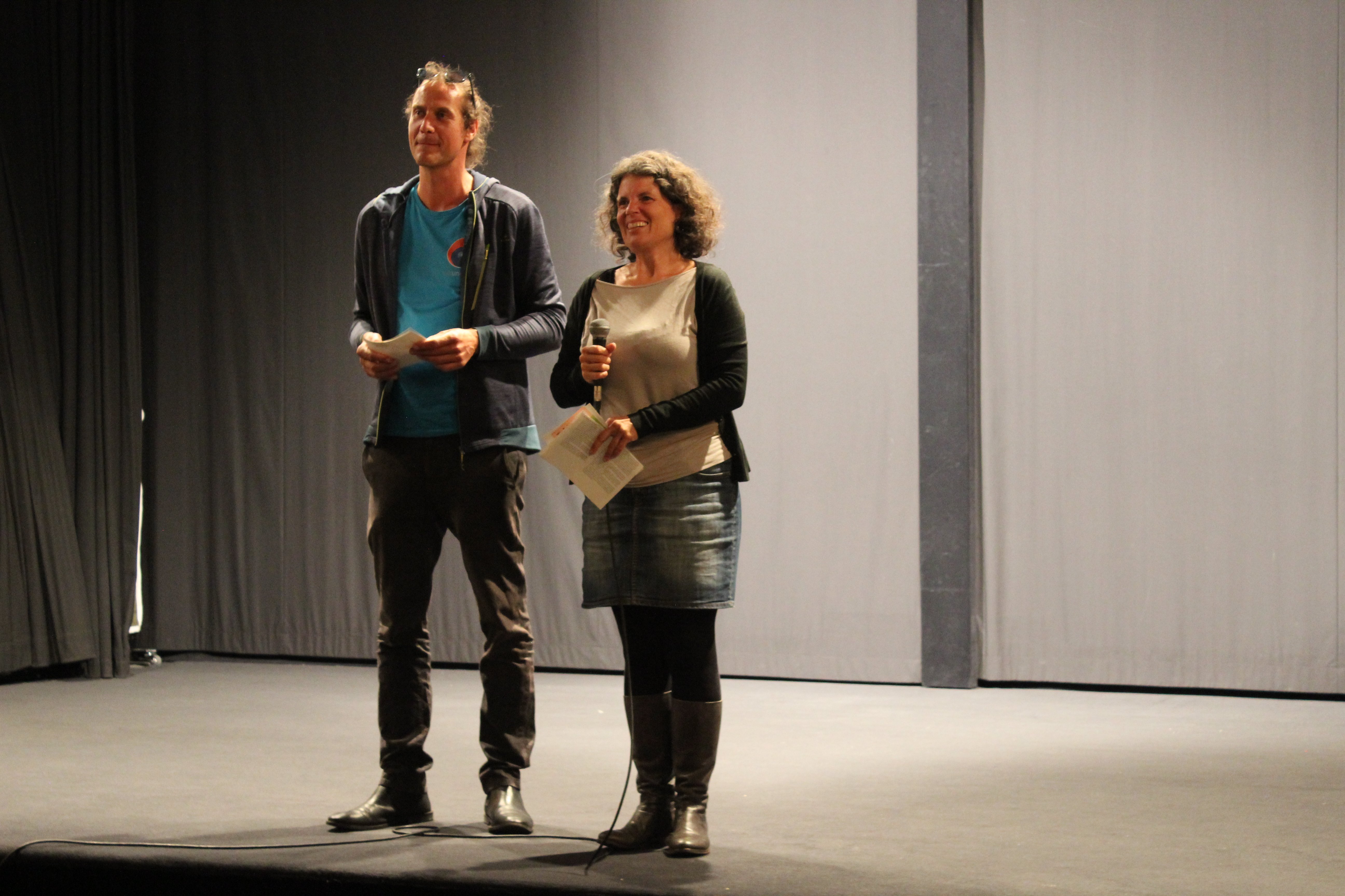Man sieht den Moderator Simon Neitzel und die Moderatorin Sarina Gisa auf der Bühne im Kino in Weingarten. 