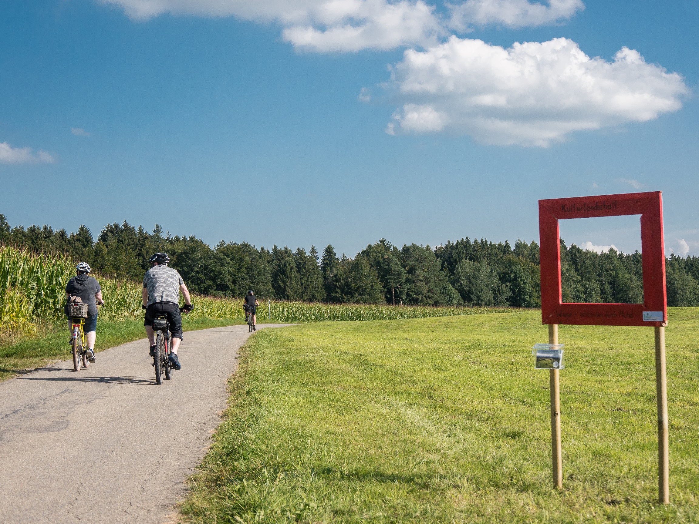 Kulturlandschaftsfenster Wiese an der Radstrecke der Umanand-Tour 2021 Radler fahren an einem Kulturlandschaftsfenster vorbei