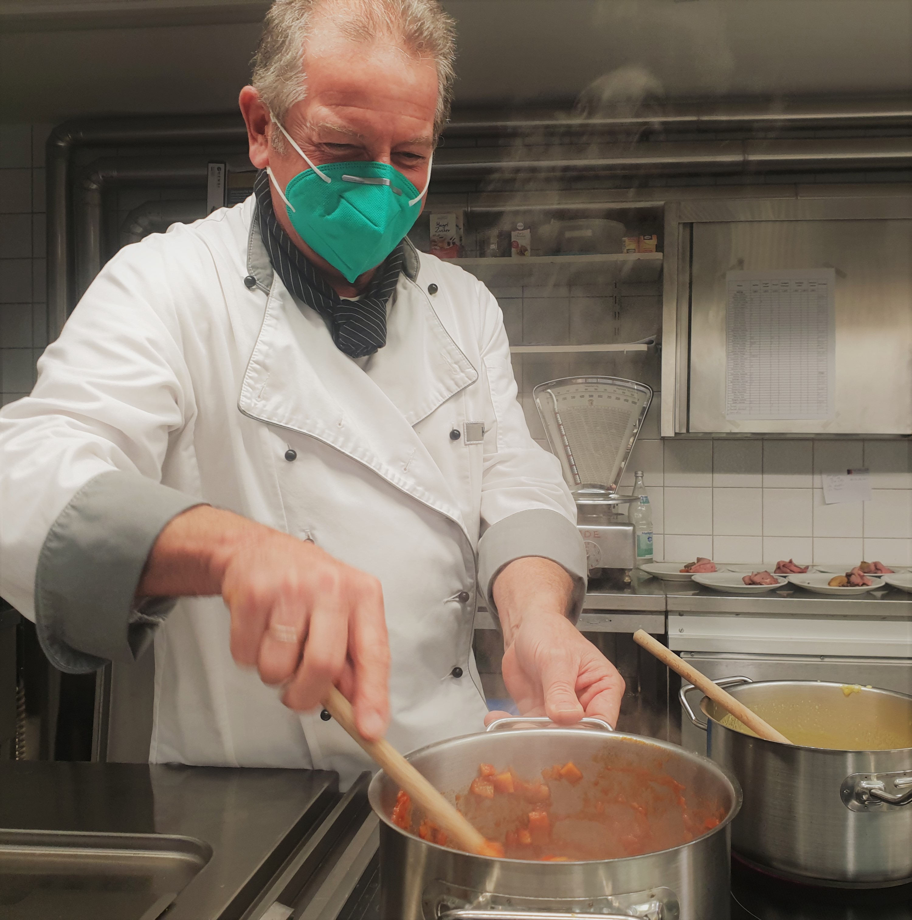 Koch rührt in dampfendem Topf