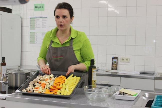 Manuela Schmied zeigt die Anordnung des Ofengemüses auf dem Backblech