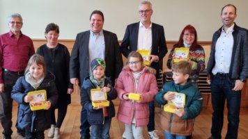 Das Bild zeigt von lins Imker Herber Klahn, Regionalmanagerin  der Bio-Musterregion Ruth Weniger, Bürgermeister Markus Haas, Leiter der Marketingkommunikation der MOSCA GmbH Frank Mutschler, Schulsekretärin Gudrun Kirschenlohr sowie Schulleiter der Winterhauchgrundschule Waldbrunn Ulrich Schöpwinkel